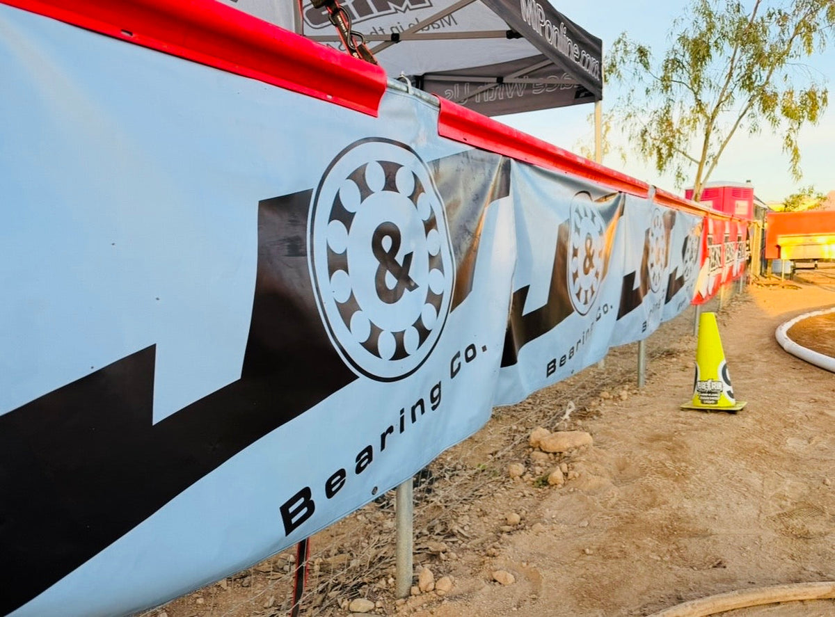Custom printed vinyl banner with grommets hung on a fence rail